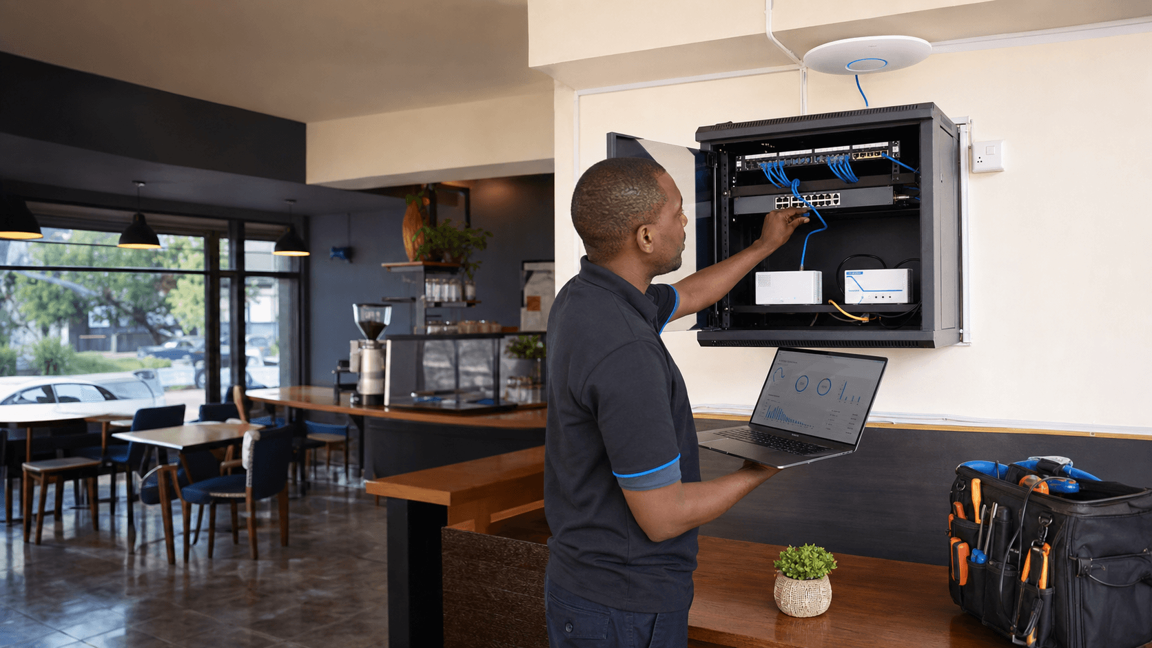 Technician configuring a business router, internet links, and WiFi access point